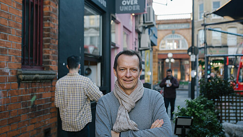 Christophe Noblet stands in an alleyway 